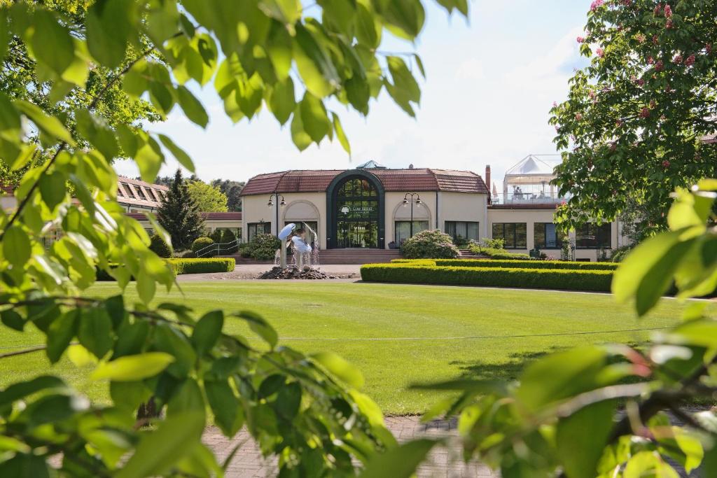 un bâtiment avec une fontaine au milieu d'un parc dans l'établissement GolfResort Semlin, à Semlin