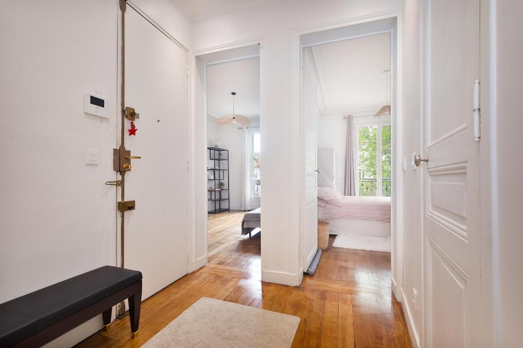 a white hallway with a door and a living room at Parisian Apartment for 3 People - Paris Parc des Princes WiFi & Metro in Boulogne-Billancourt