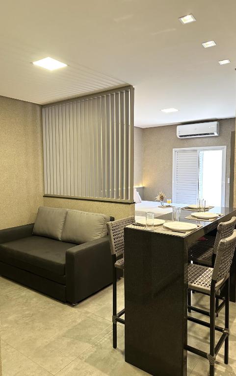 a living room with a couch and a table at Flat Bélgica Piscina e Conforto in Olímpia