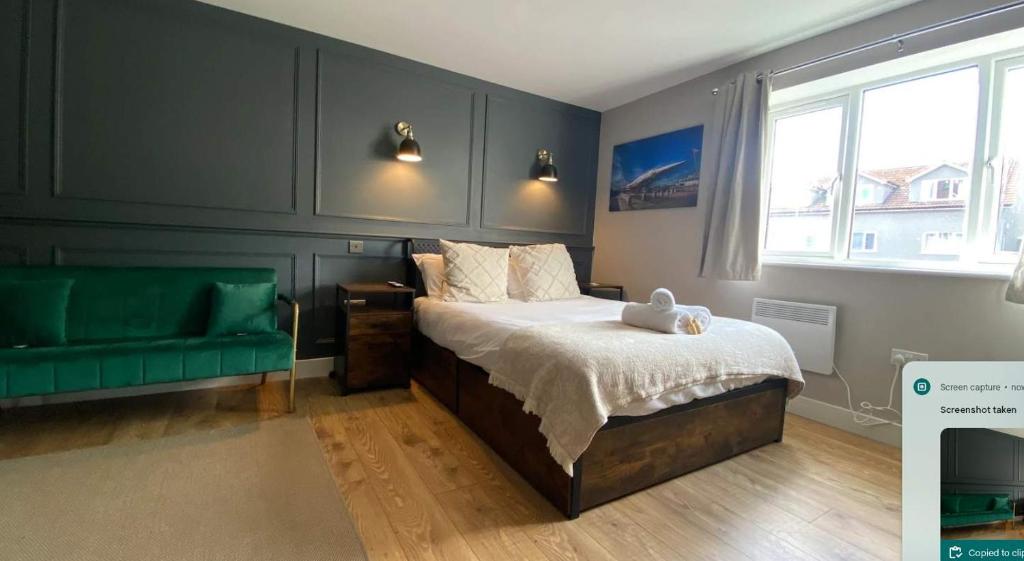 a bedroom with a bed and a green couch at The Willow - Studio 21 in Bristol