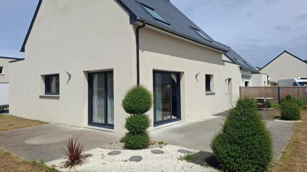 a white house with two bushes in front of it at Maison Du Bonheur in Erquy