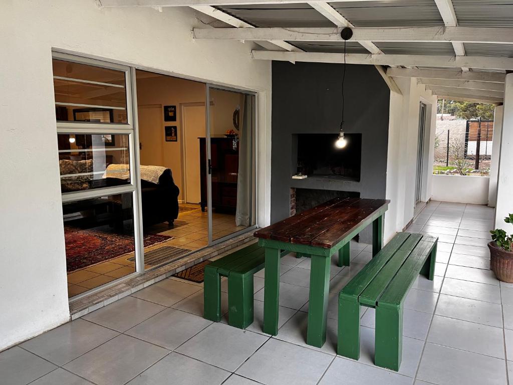 a green table and bench in a living room at Dorpshuisie in Uniondale