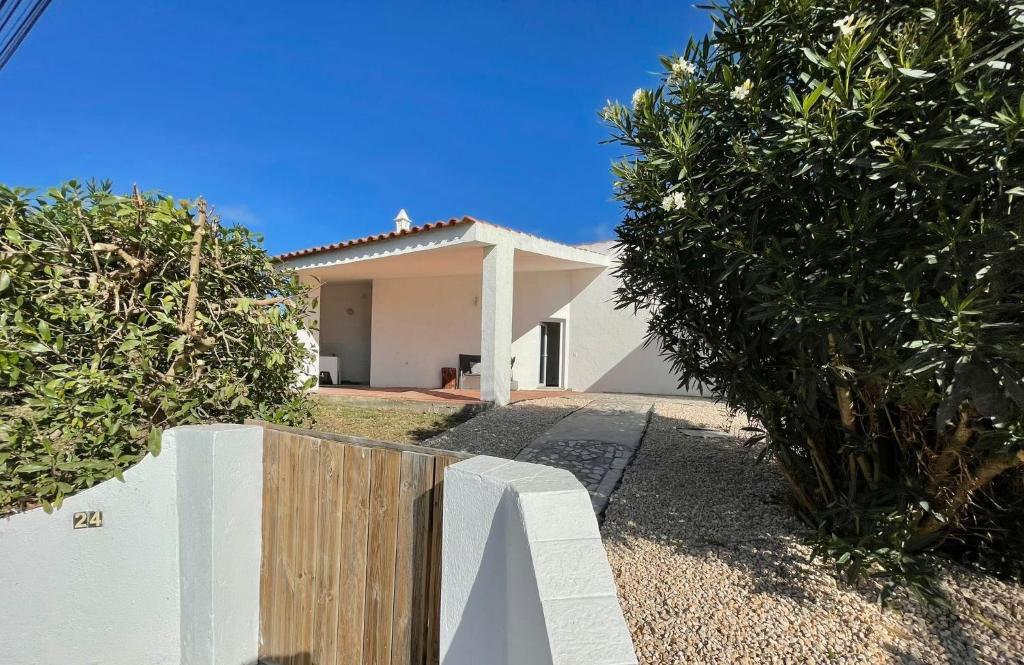 a white house with a fence in front of it at Casa da praia in Aljezur