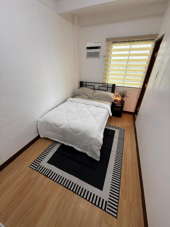 a bedroom with a bed and a black and white rug at Le Nomad Homestay in Batangas City