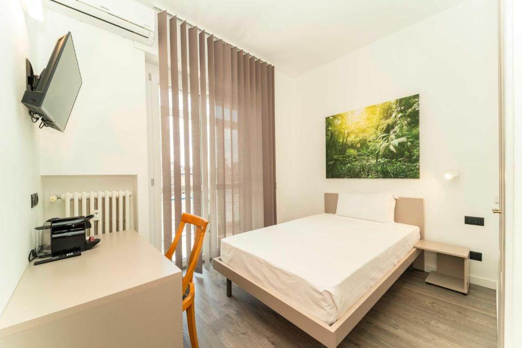 a bedroom with a bed and a desk and a tv at Inv Solution in Turin