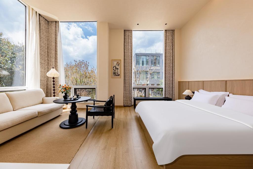 a hotel room with a large bed and a couch at Tree House Dali 清朴小院 大理 in Dali Airport