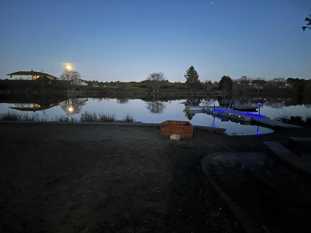 een uitzicht op een meer in de nacht met een steiger bij Gearhart Lakefront Vacation Rental in Gearhart