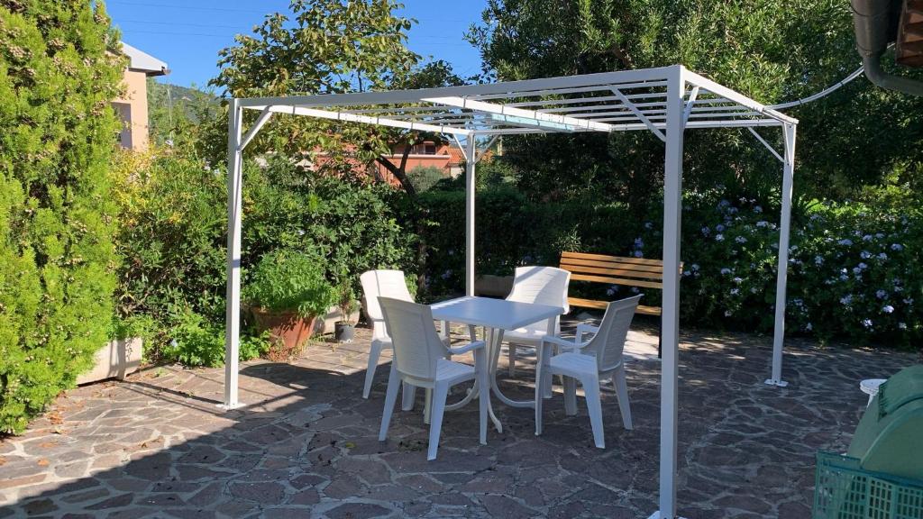 une table et des chaises sous une pergola blanche dans l'établissement Villino La Pergola, à Marina di Campo Airport