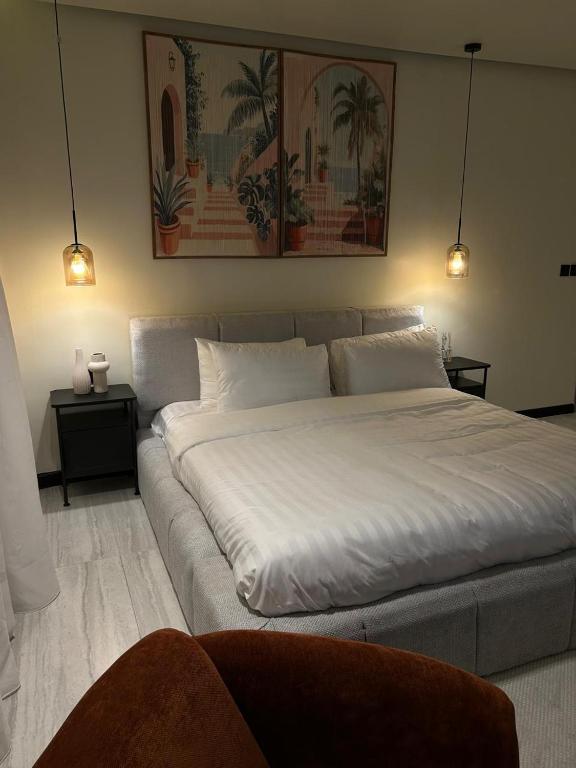 a large white bed in a room with two lights at ovation Studio in Riyadh