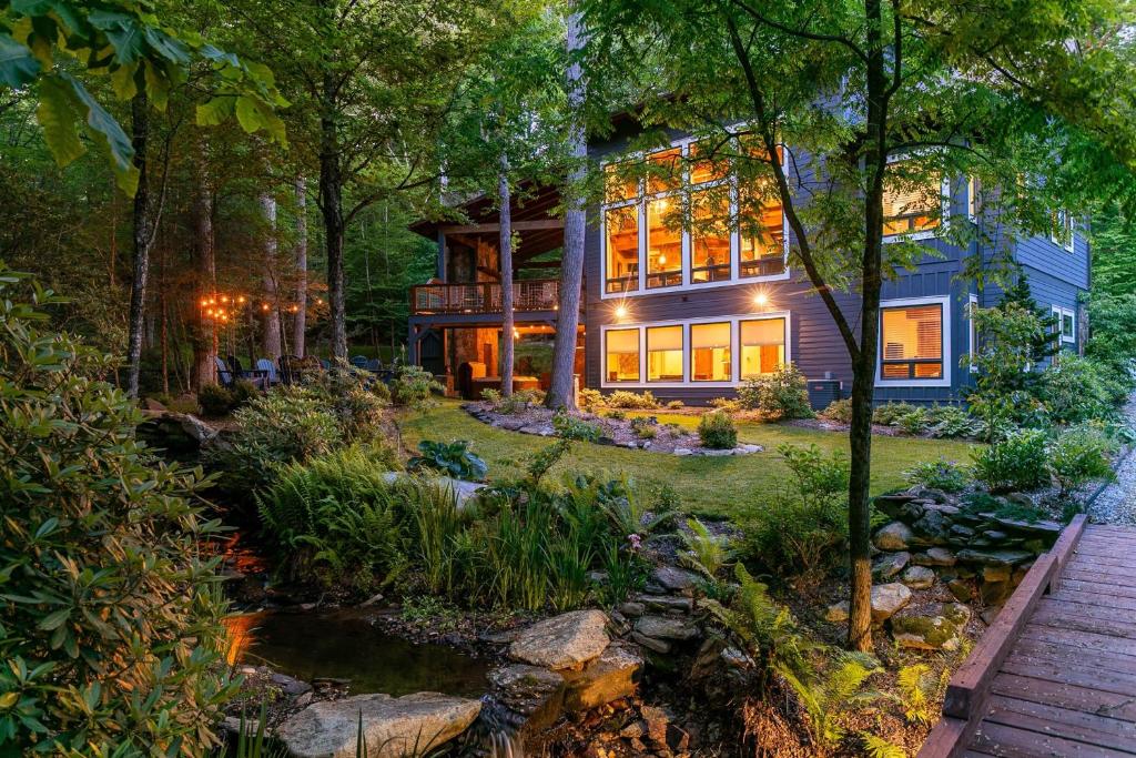 une maison dans les bois avec un étang dans la cour dans l'établissement A Robins Nest, à Blowing Rock