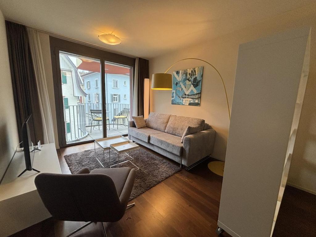 チューリッヒにあるStylish 1BR in the city center - Baron 25のソファと窓のあるリビングルーム