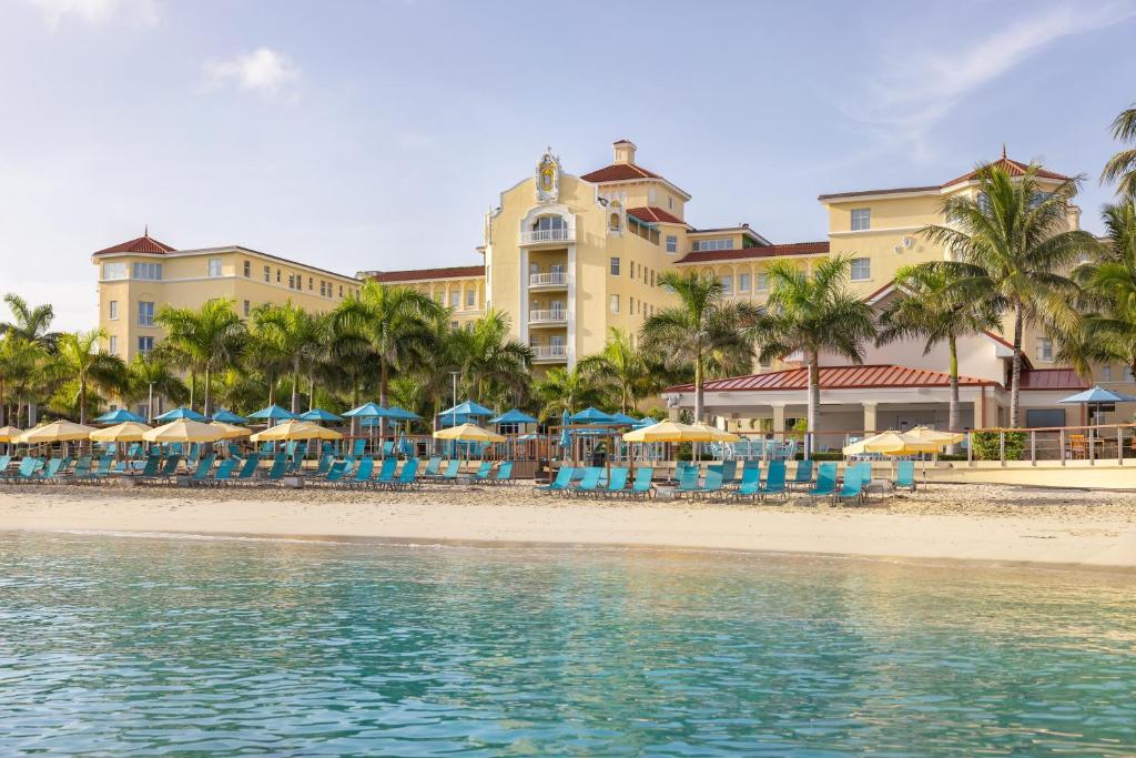 a hotel on the beach with chairs and umbrellas at British Colonial Nassau in Nassau