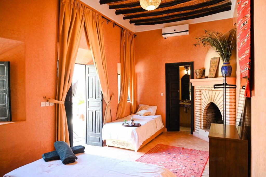 une chambre avec deux lits et une cheminée dans l'établissement Riad Sidi Hicham, à Marrakech