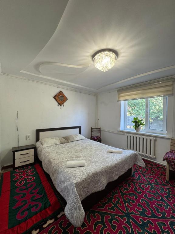 Un dormitorio con una cama grande y una alfombra. en Cozy, en Bishkek