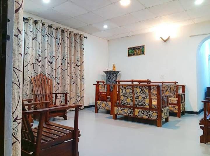a room with several wooden chairs and a curtain at Dream Image in Nikawatawana