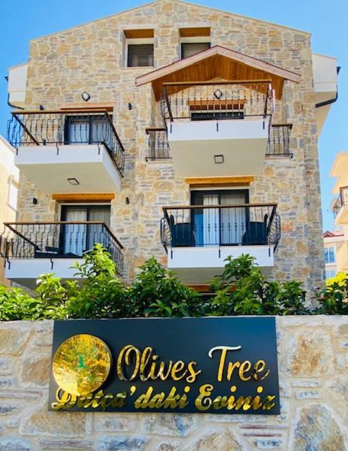 a sign in front of a building with balconies at olives tree in Datca