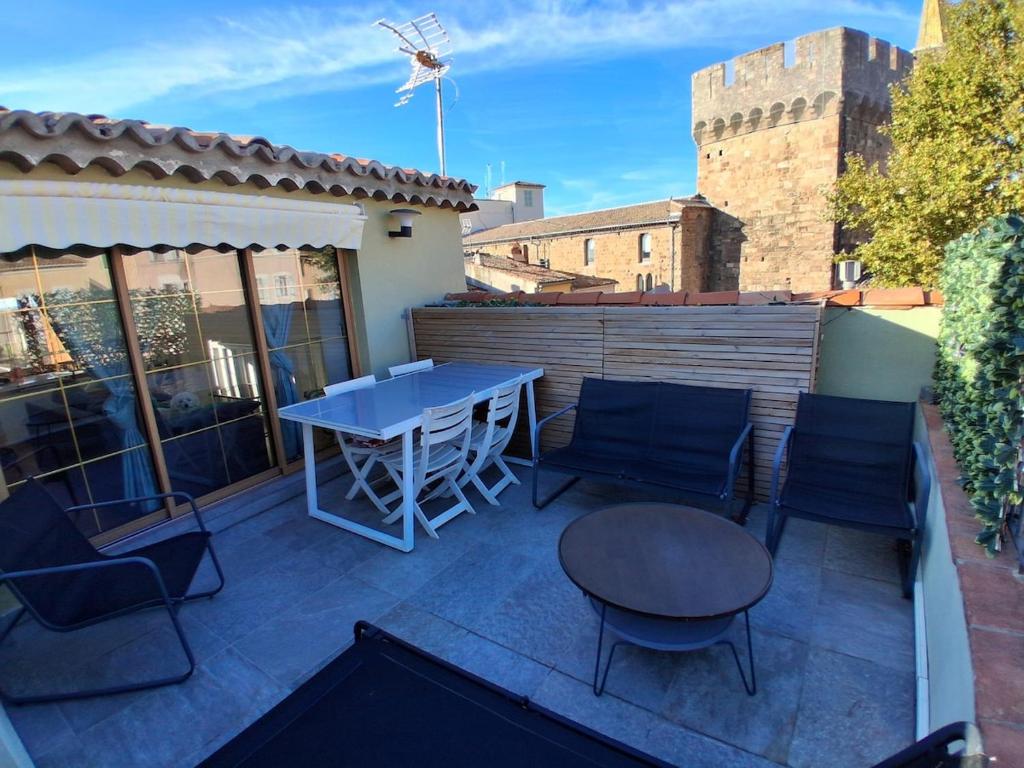 Duplex Climatisé 2chambres Centre Historique في فريجوس: فناء على طاولة وكراسي على السطح