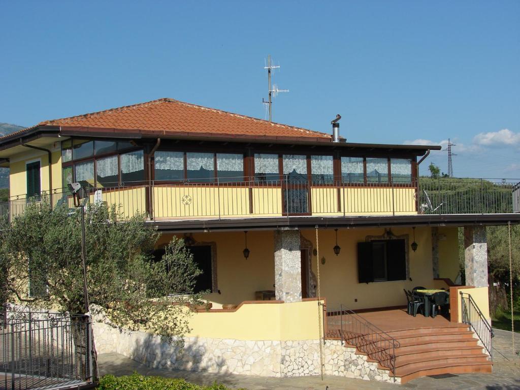 Montecorvino PuglianoにあるAzienda Agricola Carbone Cosimoのポーチとデッキ付きの大きな黄色の家
