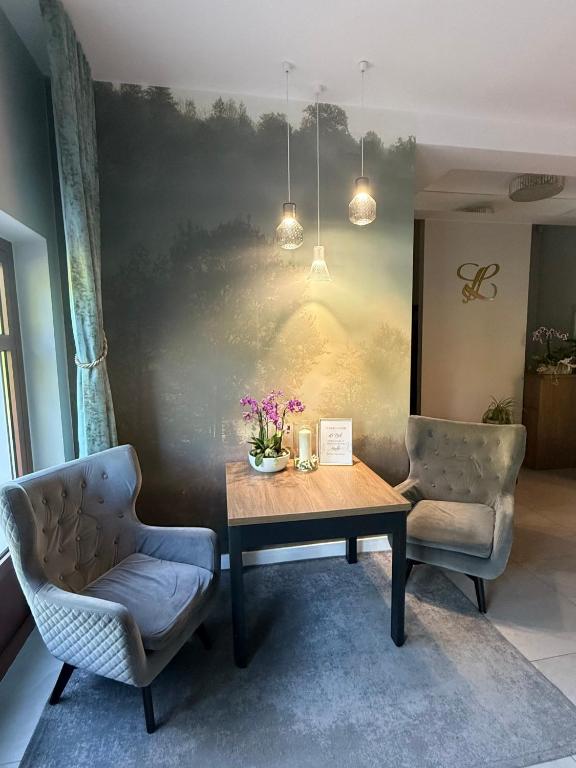 ein Esszimmer mit einem Tisch und zwei Stühlen in der Unterkunft Laura in Bełchatów