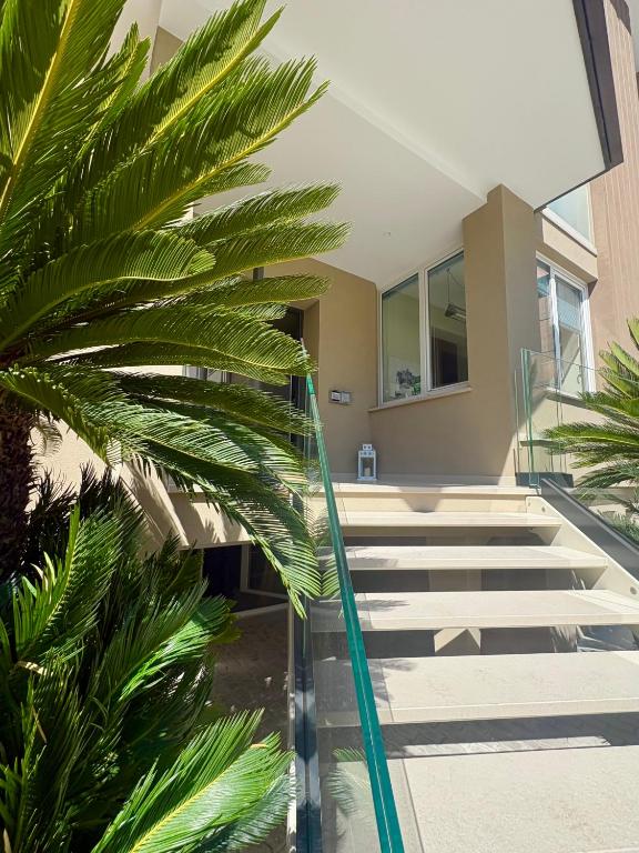 a staircase leading to a building with palm trees at Hotel Dolcevita in Cesenatico