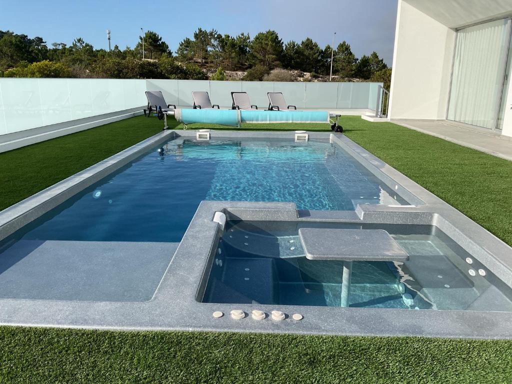 une piscine au sommet d'un immeuble dans l'établissement Golden Coast Villa - Pedra do Ouro, 15km da Nazaré, à Pedra Do Ouro