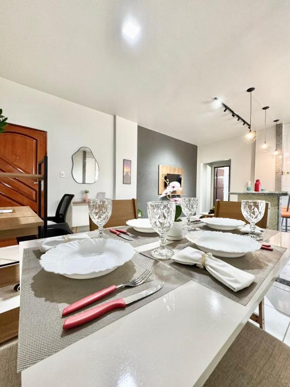 a table with plates and glasses on top of it at Ape Elegance com ar condicionado cama queen no centro in Formosa