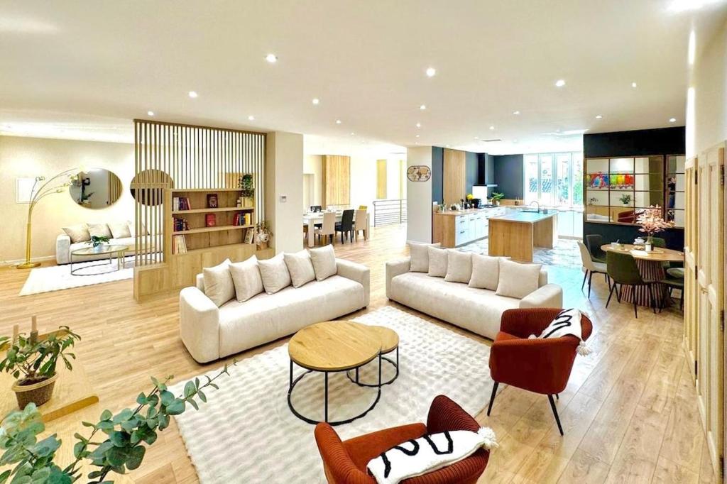 Una sala de estar con un sofá y sillas y una cocina. en Le Prestigieux - Appartement de Charme en Plein Centre-Ville - Billard - Salle Polyvalente - Terrasse - Piscine & Parking Privé - Proche A7, en Orange
