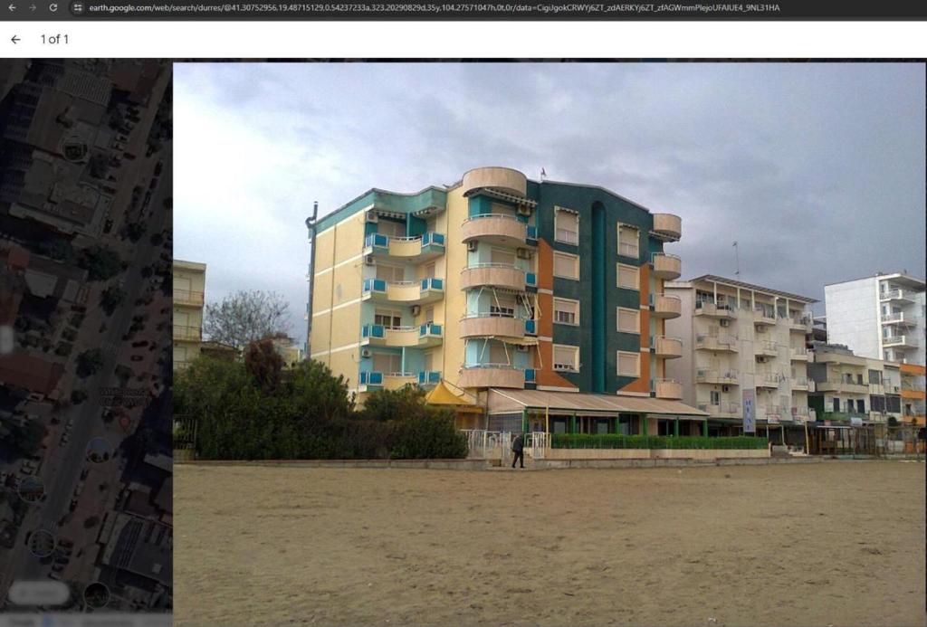 un grand bâtiment sur la plage à côté d'une plage dans l'établissement orange room, à Durrës