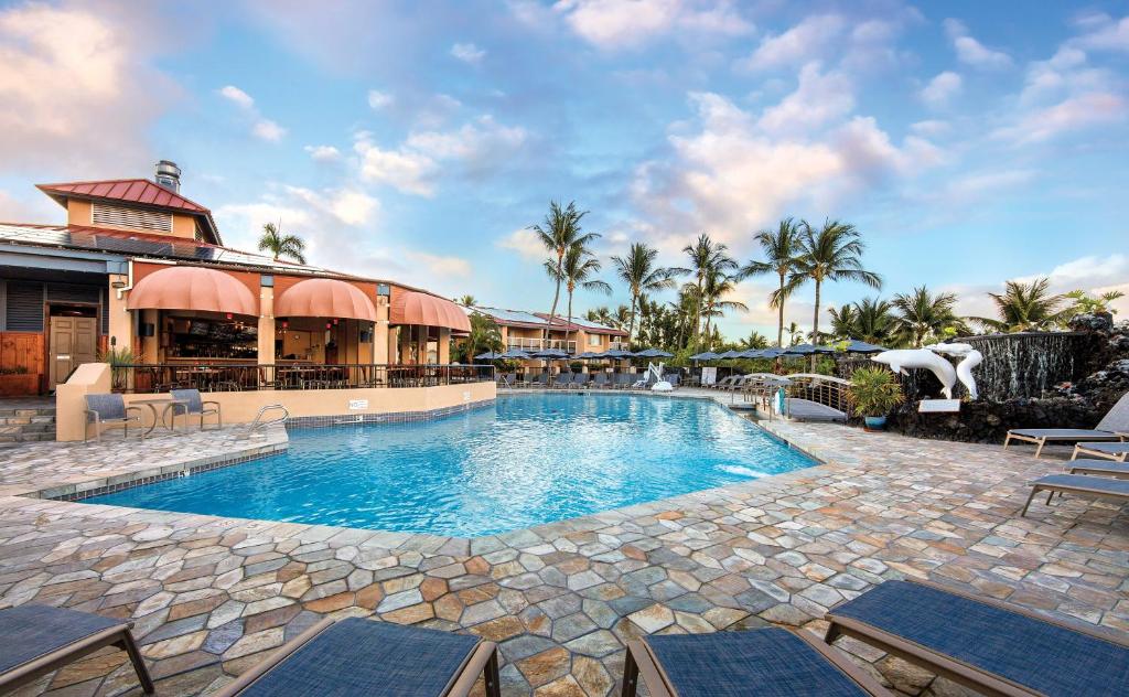 a swimming pool with chairs and a resort at Kona Coast Resort in Kailua-Kona