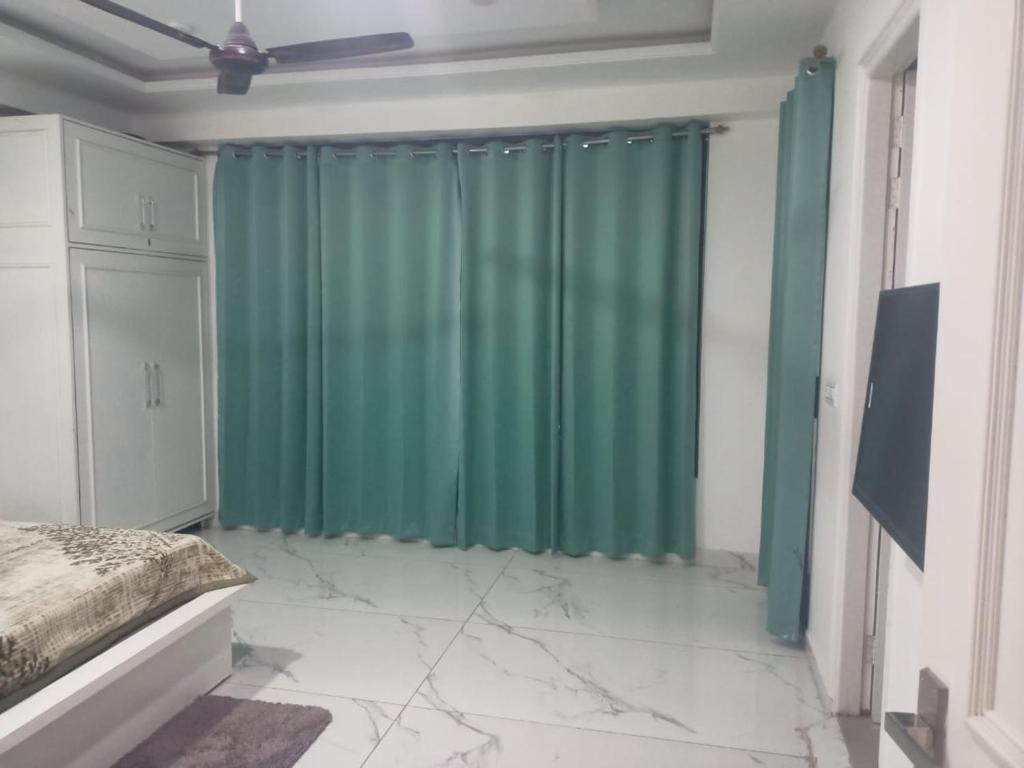 a bedroom with a green curtain and a bed at Kasauli CrestSpring in Dharampur