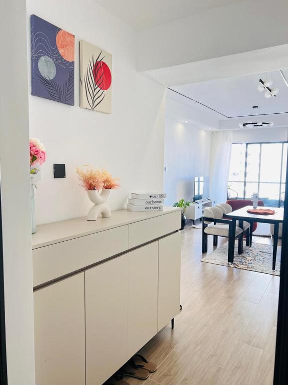 a white kitchen with a living room and a table at Raydil Homes in Nairobi