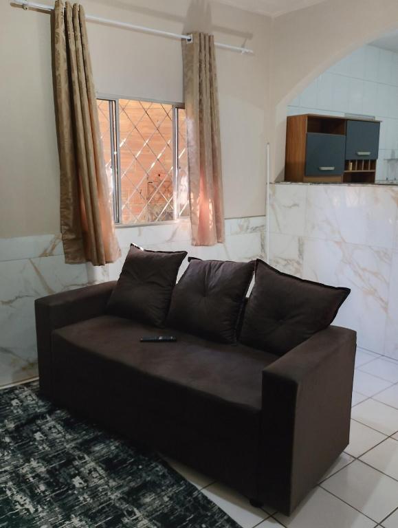 a black couch in a living room with a window at Casa 2 grande perto do pavilhão de Carapina in Serra