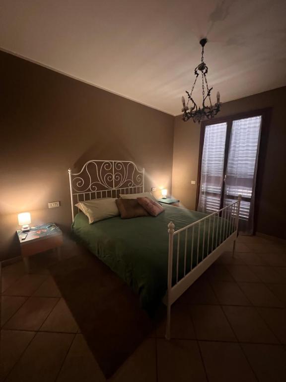 a bedroom with a bed and a chandelier at The Loft E&E Lofty Rooms in Empoli