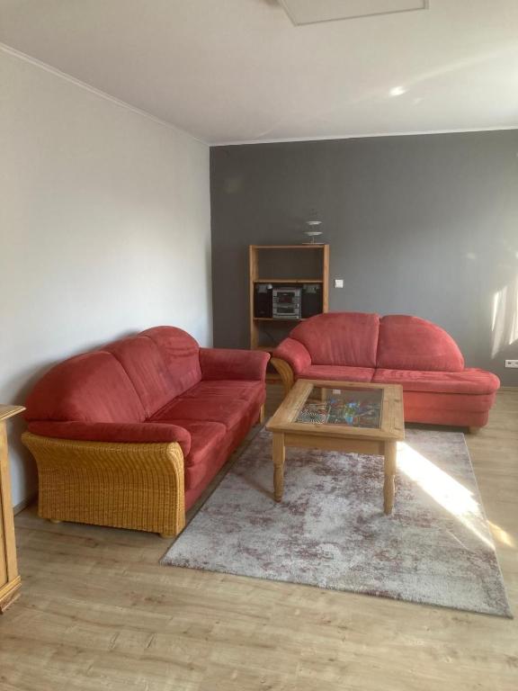 a living room with a red couch and a coffee table at Ferienwohnung für Monteure in Erlenbach am Main