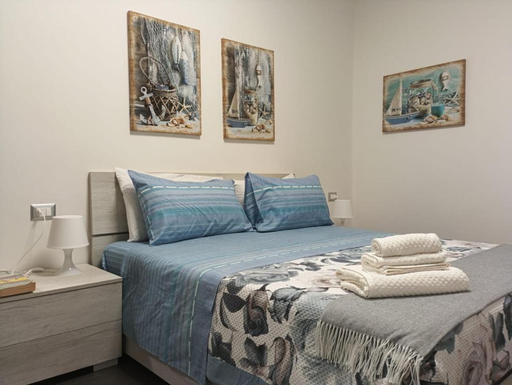 a bed in a bedroom with three pictures on the wall at sea view apartment in Siracusa