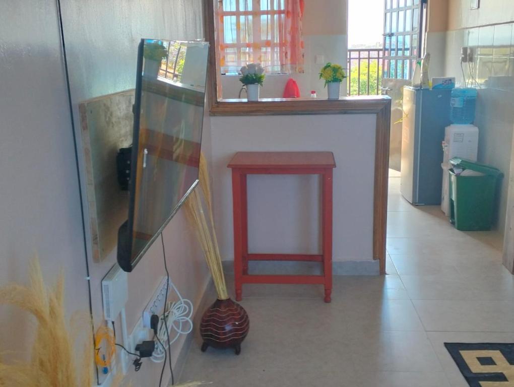 una habitación con una barra con un taburete rojo y una mesa roja en Shukrey palace 4, en Naivasha