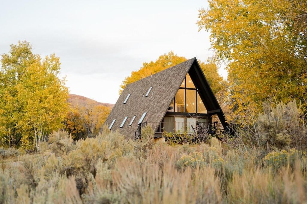 una pequeña casa en medio de un campo en A-Frame Haus Heber views romantic firepit cute, en Timber Lakes