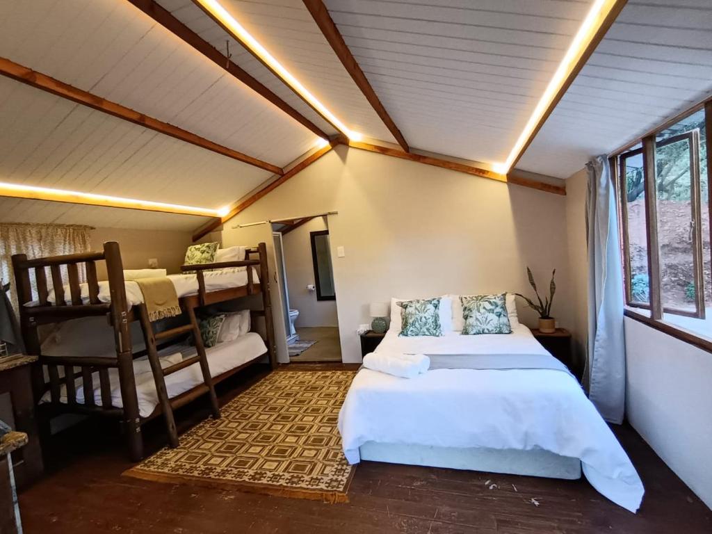 un dormitorio con una cama y una litera en Koinonia Bush Lodge, en Hartbeespoort
