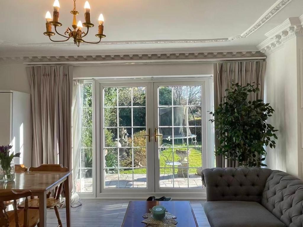 een woonkamer met een grote glazen schuifdeur bij Kuns house in Busheyheath