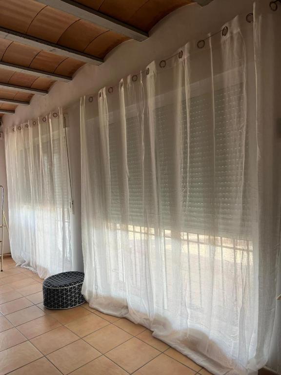 a row of white curtains on a wall at Chalet en la naturaleza in Macastre