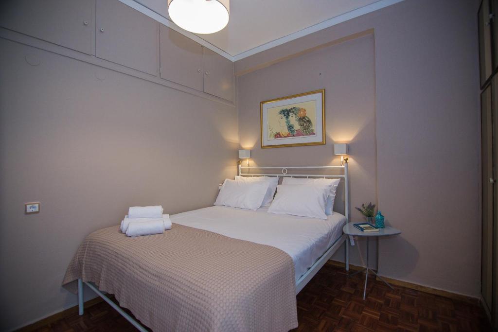 a small bedroom with a white bed and a table at Centro Urban Chania in Chania