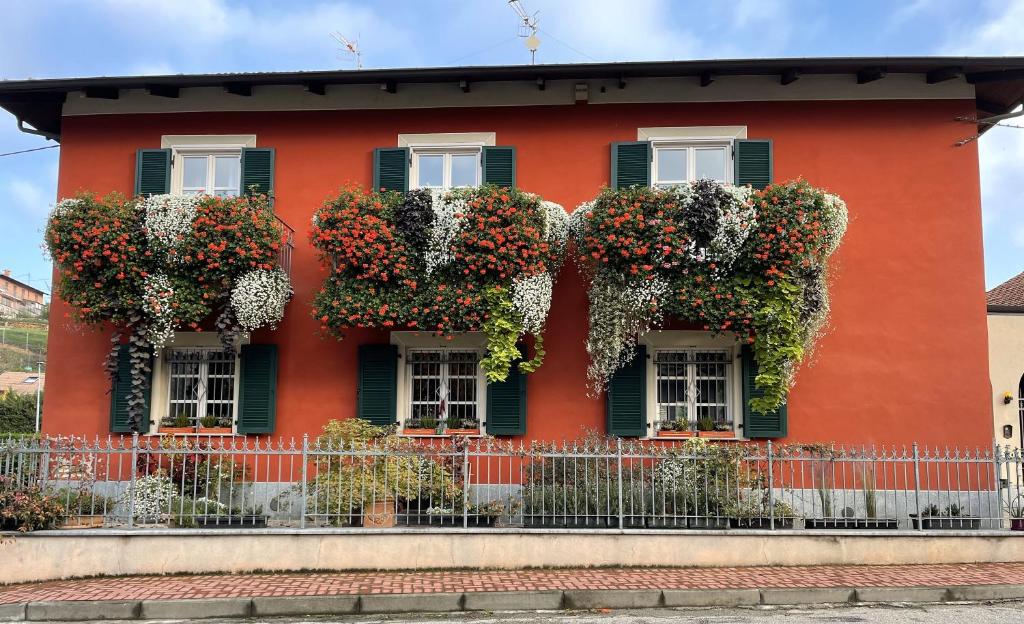 a red house with flowering plants on it at Aperegina in Castellinaldo