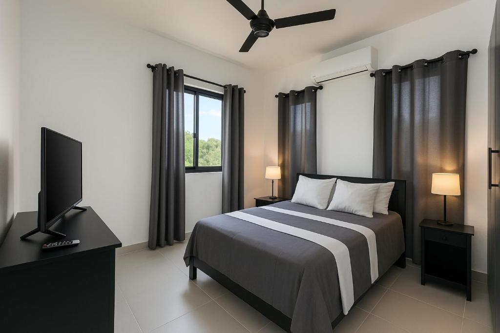 a bedroom with a bed and a flat screen tv at 3 Bedroom Penthouse with private Rooftop Terrace in Sosúa