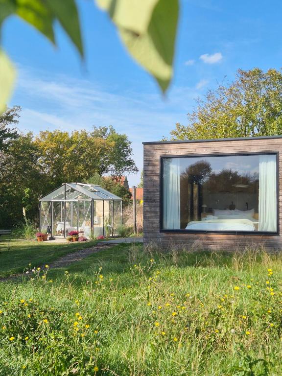 a house with a large window in a field at New! Tiny House Lantliv Oostkapelle, met weidezicht in Oostkapelle