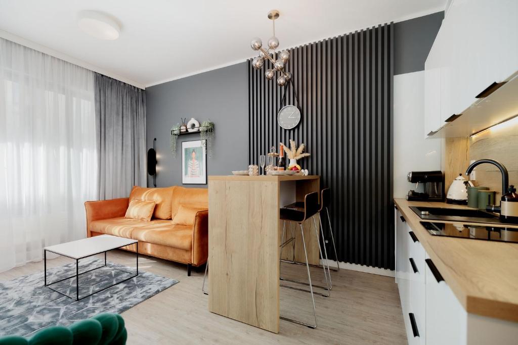 Una cocina y una sala de estar con un sofá y una mesa. en Baltic 4YOU 3, en Pobierowo