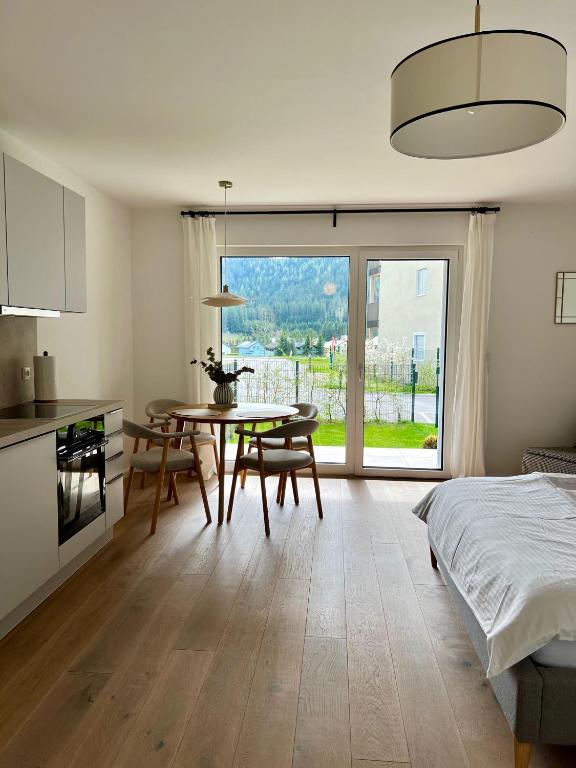 a kitchen and dining room with a table and a bed at Gartenapartment Mariazell in Mariazell