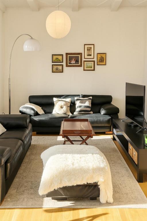 a living room with a black couch and a table at Stubel-Riedisheim in Riedisheim