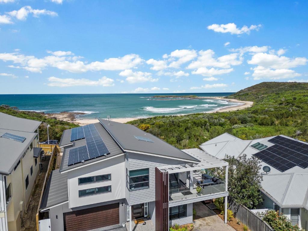 Catherine Hill BayにあるSurfsideの海辺のソーラーパネル付きの家屋の空中風景