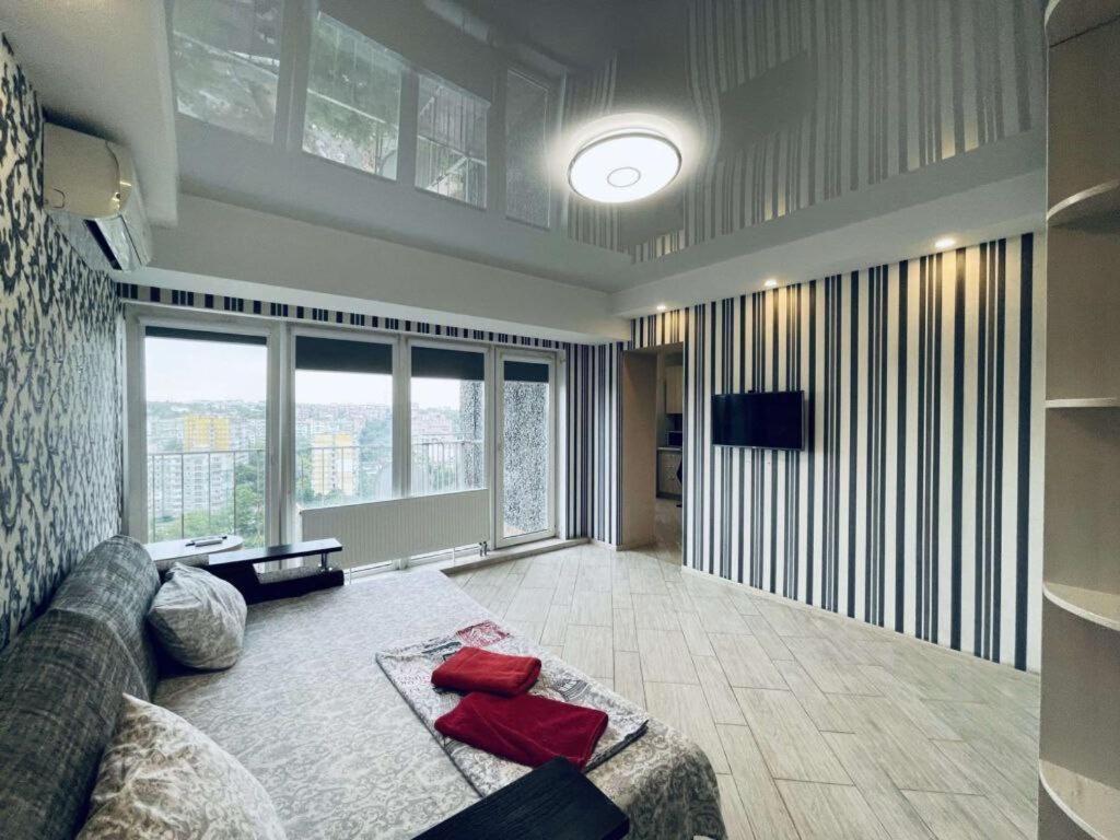 Квартири подобово центр في دنيبروبيتروفسك: غرفة معيشة مع أريكة ونافذة كبيرة