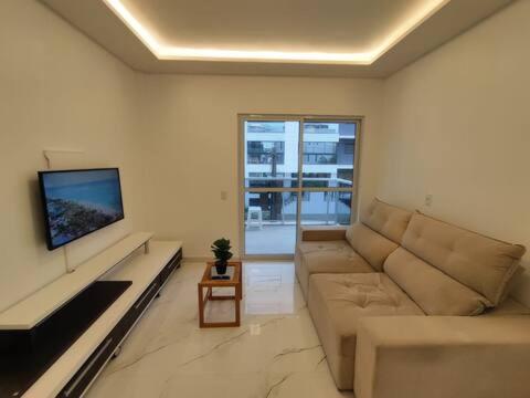 ein Wohnzimmer mit Sofa und Fernseher in der Unterkunft Residêncial Campinas a 400 Metros da praia de Palmas in Governador Celso Ramos